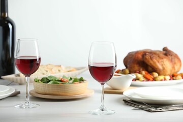 Red wine and delicious dinner served on light table