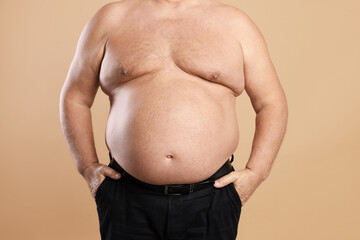 Naklejka premium Man with excessive belly fat on beige background, closeup. Overweight problem