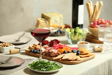 Red wine and different snacks served on table