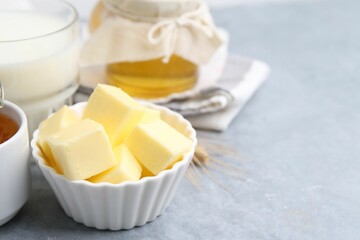 Fresh butter, honey and milk on light grey table, closeup. Space for text