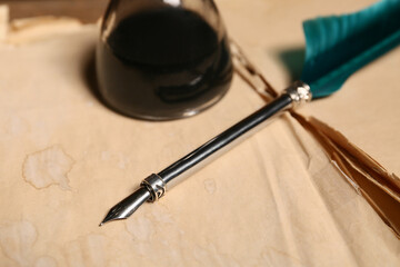 Naklejka premium Old book with nib pen and inkwell, closeup