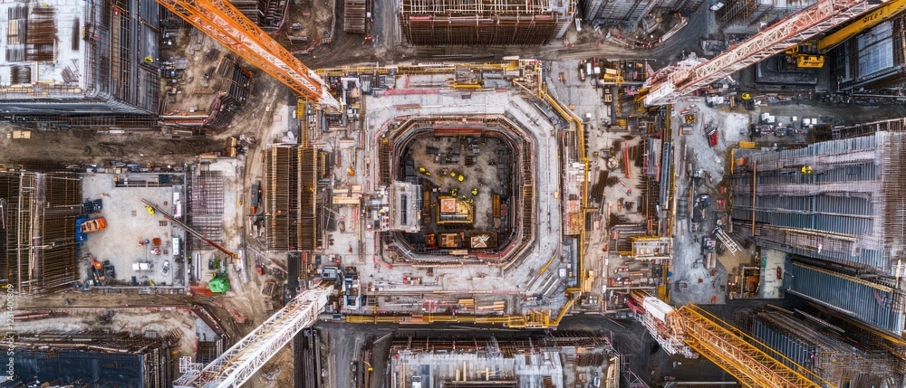 Poster aerial view of a large construction site with multiple cranes and workers.