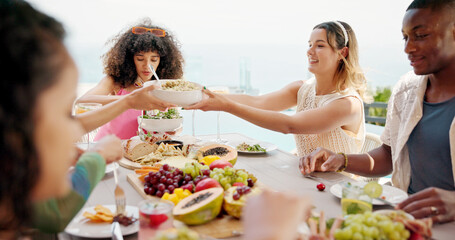 Happy people, eating or passing with food at resort for lunch, meal or get together by table. Group, hungry friends or event with bowl, hospitality or dining for feast, holiday party or weekend