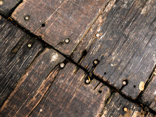 meeting of wooden planks used as flooring with rusty nails and damaged planks