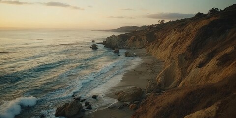 Sunset view of ocean waves crashing on a secluded beach next to dramatic cliffs.