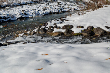 雪が積もった冬の川　清流　長野県白馬村