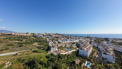 Obraz premium Aerial drone photo of the beautiful town of Sitio de Calahonda taken in the winter time showing residential and holiday home apartments with the ocean front in the background on a bright sunny day