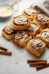Freshly baked cinnamon rolls topped with icing and almond slivers