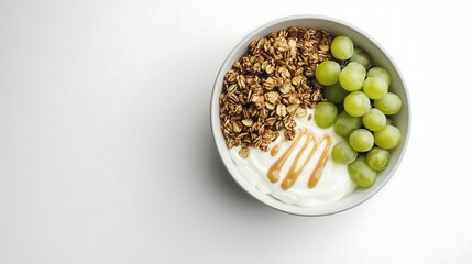 White bowl of yogurt topped with granola, green grapes, and a drizzle of maple sauce, on a minimalist white background, top-down view 