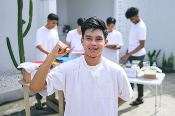 Young Teenage Volunteer Raising Fist Giving Motivation For Charity Movement 