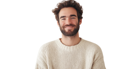 Man with curly hair and beard smiles warmly while wearing a cozy sweater in a bright indoor space
