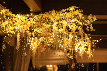 Festive decorations with warm lights hanging from the ceiling in a cozy interior setting