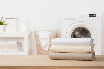 Stack of clean folded textile duvet covers on blurred laundry room background