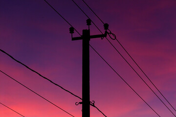 A tall power pole with wires hanging from it