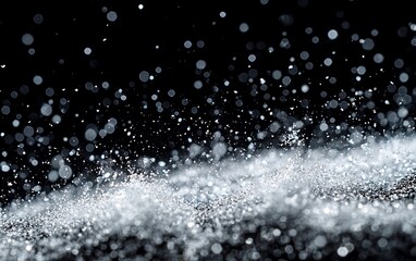 Sparkling silver glitter texture on black background.