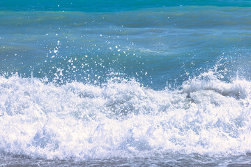 Fototapeta premium Nerja town, a resort of The Costa del Sol seaside region in Andalusia in the south of Spain. Ocean waves crashing on the shore, creating a frothy whitecap.