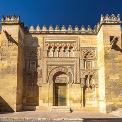 Obraz premium The Mosque–Cathedral of Cordoba, Cathedral of Our Lady of the Assumption in Cordoba town in Spain. Ornate entrance to a historic building, showcasing intricate stone carvings and large arched doorway.