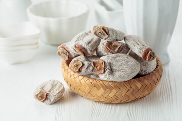 Dried persimmons on a white wooden table.