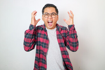 Fototapeta premium Shocked and alarmed asian man reacting to terrible news, standing in panic over white background and shaking hands indecisive, dont know what do, feeling useless, white background