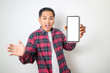 Young Asian man looking to camera, smiling and showing empty blank white copy space phone mock up template