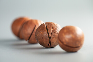 Close-up shot of a cluster of macadamia nuts, showcasing their natural beauty and texture. Nuts are...