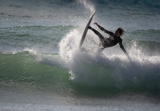 Surfer performing trick on ocean wave