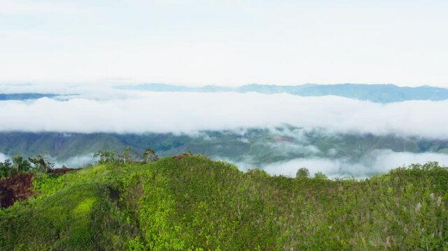 A breathtaking forward drone shot captured at Uraya's Peak in Talaingod, Davao del Norte, Philippines. The footage begins with lush green landscapes and reveals mountains with sea of clouds.