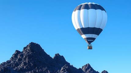 Fototapeta premium White and Gray Hot Air Balloon Over Dark Mountains Under Blue Sky