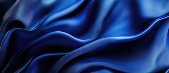 Obraz premium Abstract deep blue silk fabric with soft waves and textures, creating a smooth backdrop with ample copy space for creative design projects.