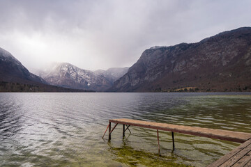 Bohinj lake with forest covered mountains in Julian Alps in winter. Popular touristic destination...