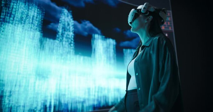 Female Urban Designer Immersed in Virtual Reality, Reimagines a Futuristic City. Virtual Production Screen Displays a Cityscape Polygon Model that is Transformed and Manipulated in Real-Time