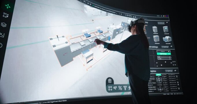 Robotics Specialist Programs a Group of Robotic Arms with the Help of Virtual Reality Metaverse. Specialist Utilizes VR to Program the Assembly Line, Optimize Production and Improve Efficiency