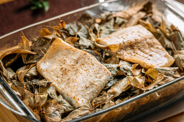 Closeup on portion of baked white fish in a glass pan