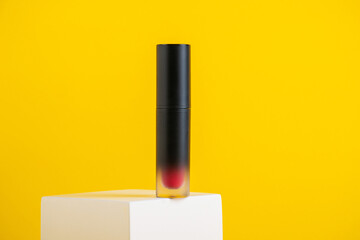 Mockup of black blank thin tube - mascara, lip gloss, gel, eyeliner, oil, etc. Cosmetic package with stylish props on yellow background.