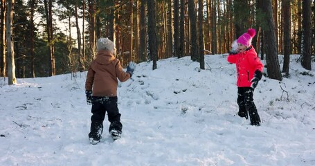 snowball fight. kids have fun outdoors in winter - Powered by Adobe