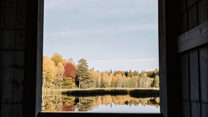 Fototapeta premium serene autumn landscape framed by rustic window, showcasing vibrant trees reflecting in calm lake
