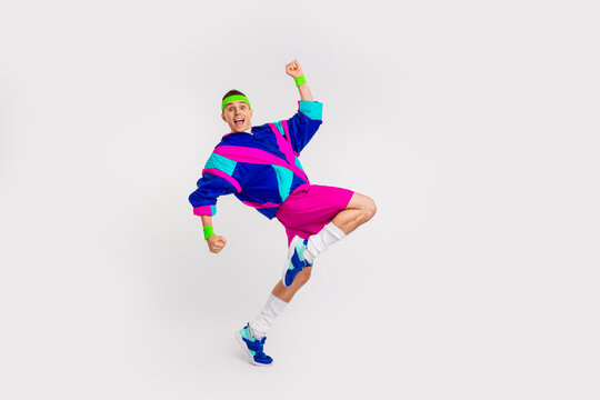 Energetic young man in retro athletic outfit striking a dynamic pose in colorful sportswear