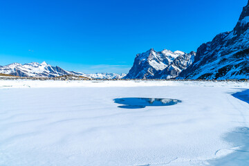Winter landscape with frozen lake on Kleine Scheidegg mountain in Swiss Alps in Grindelwald ski resort, Switzerland