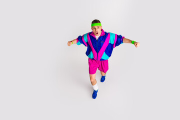 Energetic young man in colorful retro activewear on white background, embodying vibrant and funky lifestyle.