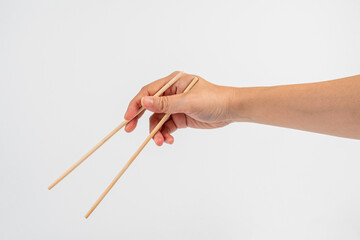 Wood chopsticks for rice and hand on a white background