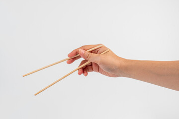 Wood chopsticks for rice and hand on a white background
