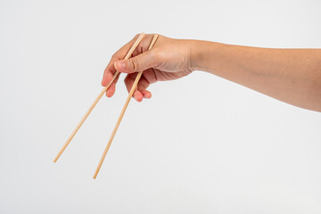 Wood chopsticks for rice and hand on a white background
