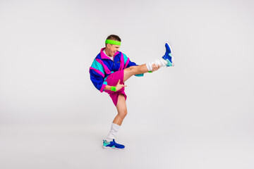 Energetic young man in colorful retro sportswear performing a dynamic exercise