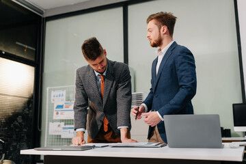 Diverse professionals collaborate on project analysis with financial graphs. Strategic teamwork and...