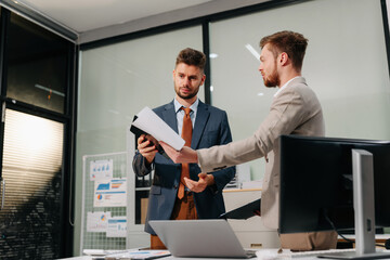 Diverse professionals collaborate on project analysis with financial graphs. Strategic teamwork and insights drive company growth and success.