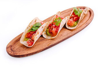 Three colorful tacos on a wooden platter with fresh toppings ready to serve at a casual dining setting