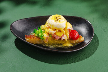 Delicious poached eggs with hollandaise sauce served on toasted bread with broccolini and cherry tomatoes in a cozy restaurant setting