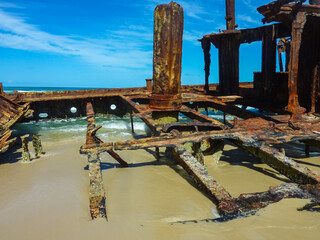 Rusted shipwreck remains of SS Maheno on Fraser Island 75 Mile Beach. Vibrant blue sky....