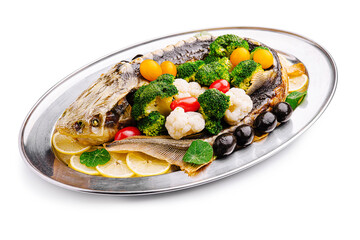 Deliciously prepared whole fish garnished with fresh vegetables on a silver platter