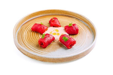 Delicate rolls of fresh tuna served on a stylish plate with creamy sauce and garnished for a fine dining experience